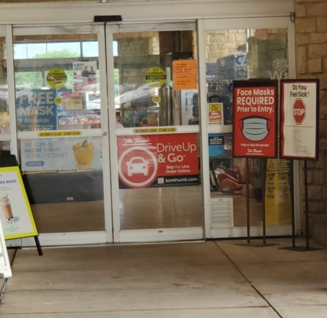 Photo shows signs outside a grocery store asking patrons to wear masks.