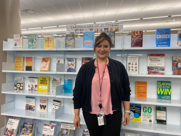 Jessica Diaz, library services manager at the George W. Hawkes Downtown Library in Arlington, standing before a row of books.