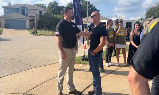 Purple Heart Homes chief executive officer John Gallina, left, greets Army vet and Purple Heart recipient Carlos Colón-Ruiz for the unveiling of the home renovations for Colón-Ruiz.