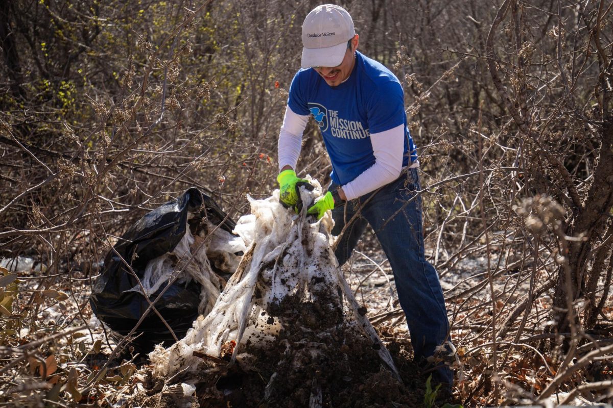 Mansfield resident Julio Alvarez pulls up plastic from the dirt during the Fish Creek Clean-Up event up Feb. 24 at Fish Creek Linear Park. Alvarez is a graduate of the University of Texas at Arlington.