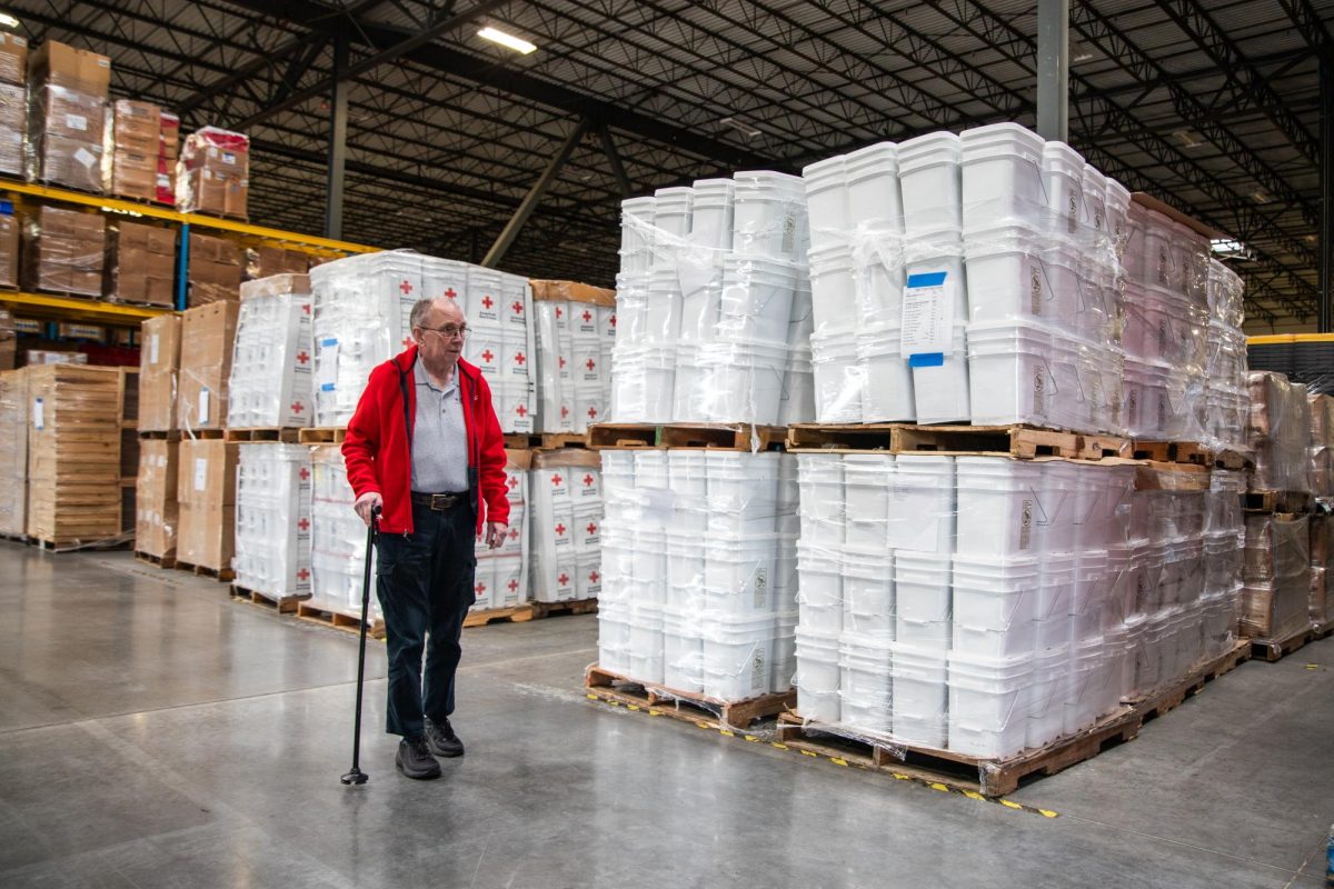 Red Cross North Texas regional manager Joel Moore walks by pallets on March 27 at American Red Cross Arlington. The pallets consist a variety of kits such as wildfire, kitchen and comfort kits.