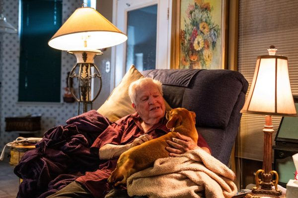 Arlington resident Vance Pointer, 81, looks at and pets his dog April 27 at his Arlington home. Pointer had his first job at a radio station in Brookfield, Missouri, in 1961.