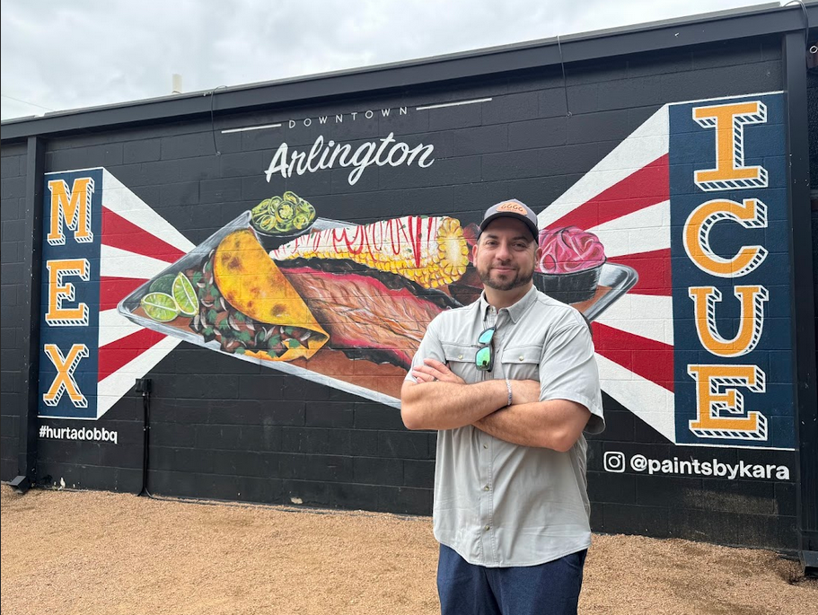 Hurtado Barbecue Restaurant founder and owner Brandon Hurtado poses in front of a mural at his Arlington, Texas, location. 