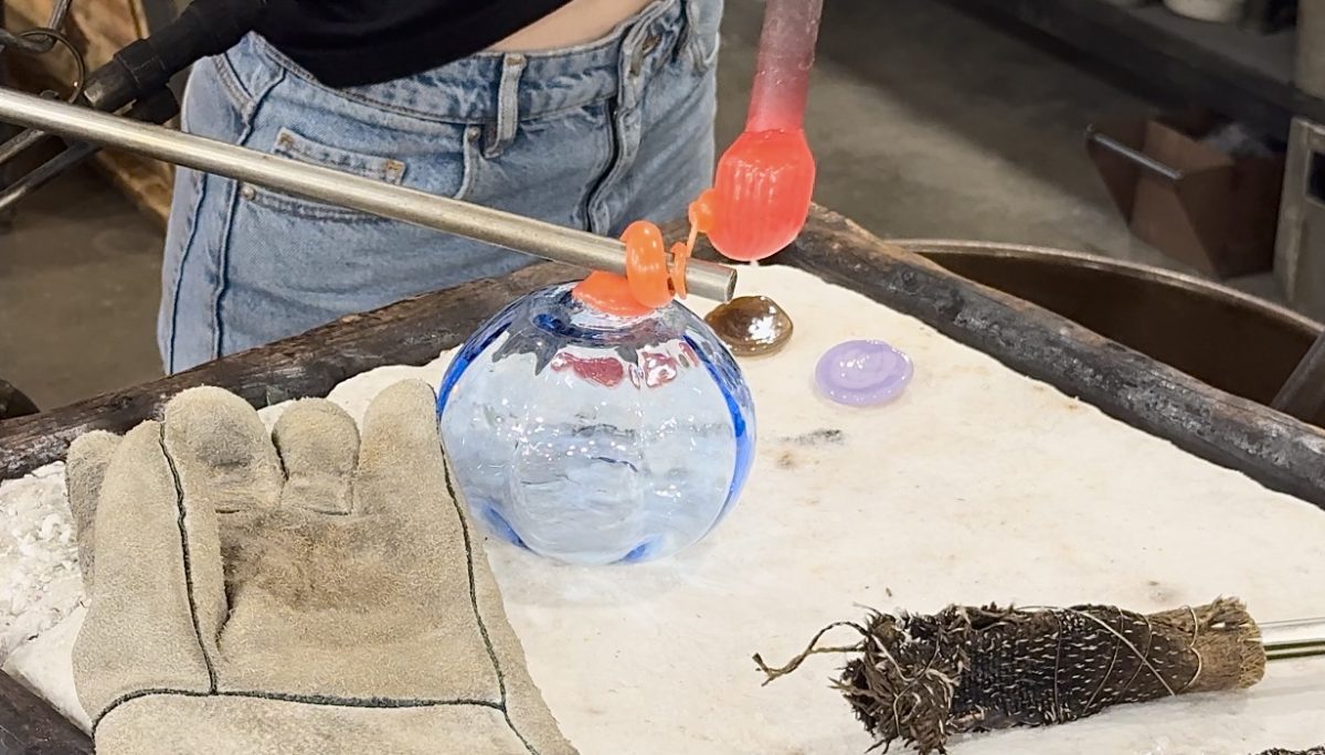 An artisan carefully curls a stem onto a glass pumpkin. Glass pumpkins like this will be available for purchase at the 12th Annual Glass Pumpkin Sale and Fundraiser, which is scheduled for Oct. 19 at the University of Texas at Arlington's Studio Art Center.